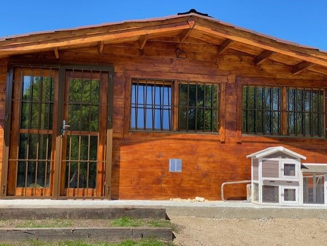 Cabaña de madera con conejeras exteriores